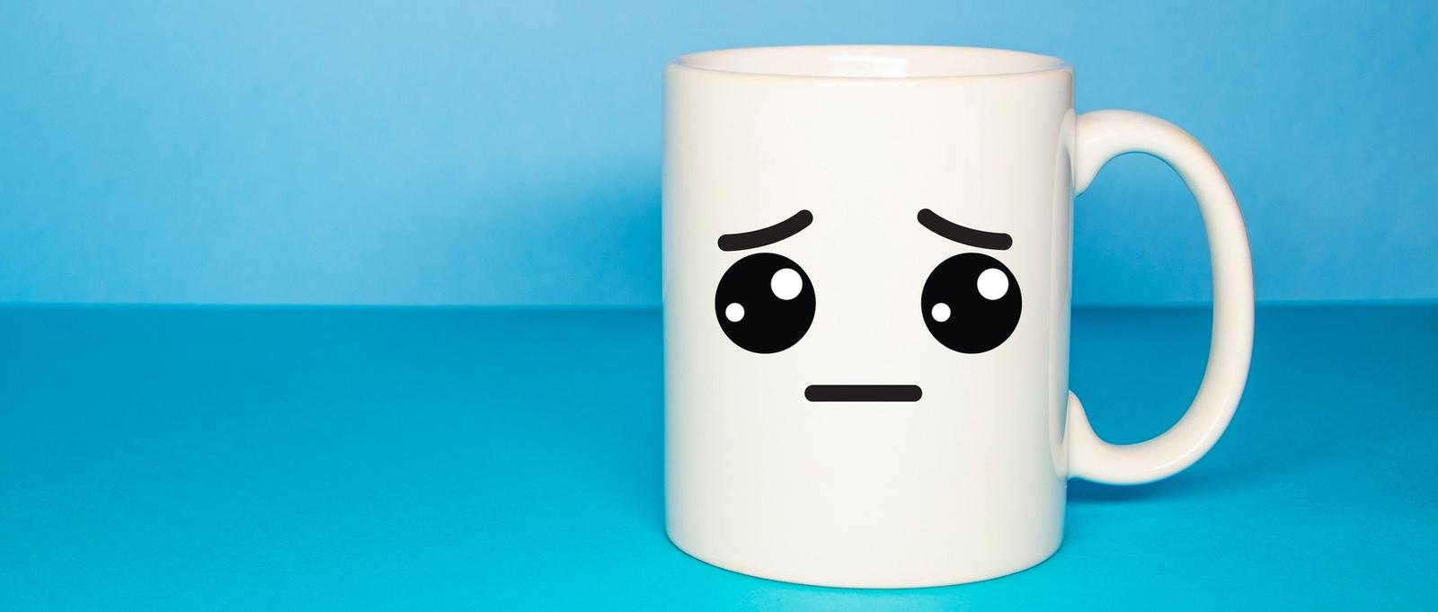 Blaue Tasse mit einem traurigen Smiley
