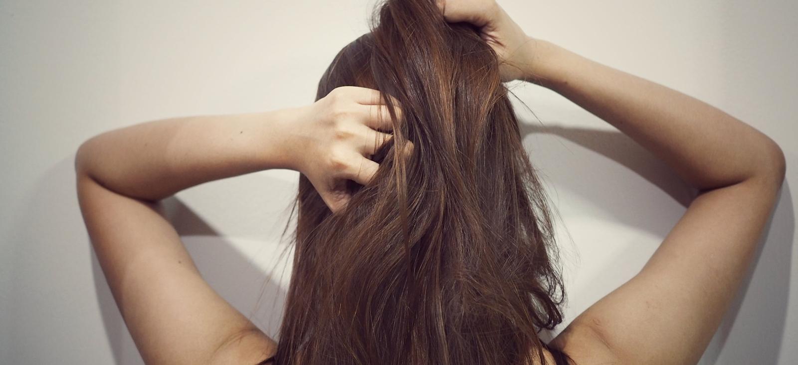 Eine Frau kratzt sich am Hinterkopf.