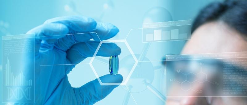 Eine Hand in einem blauen Handschuh hält eine Kapsel mit digitalen wissenschaftlichen Overlays, die chemische Formeln und Datendiagramme zeigen.