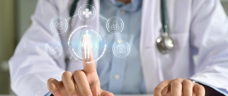 Arzt mit Stethoskop, der eine digitale Gesundheitsschnittstelle mit menschlicher Figur und medizinischen Symbolen berührt.