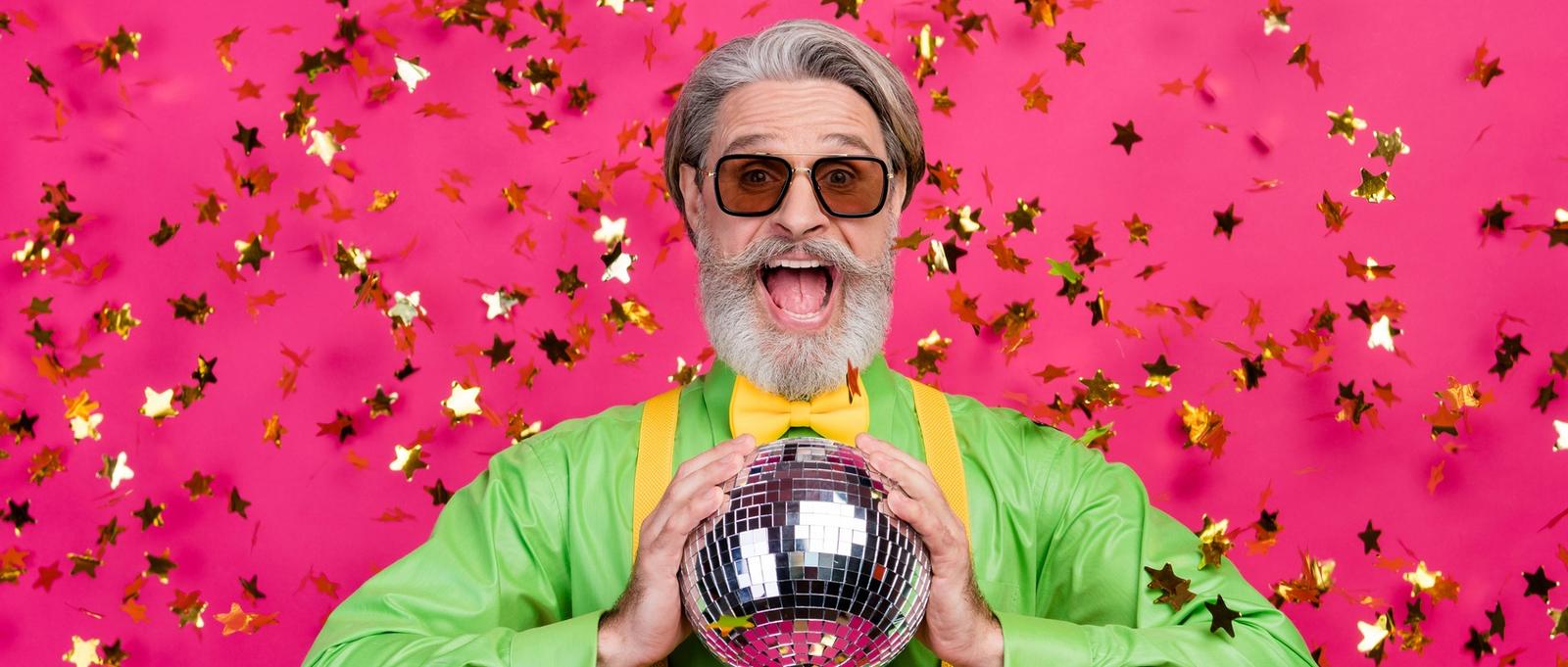 Foto von lustigen Opa Party Club Konfetti fallen aufgeregt offenen Mund halten glühenden Discokugel tragen Sonne Brille grünes Hemd gelbe Hosenträger Fliege, isoliert Glanz rosa Farbe Hintergrund
