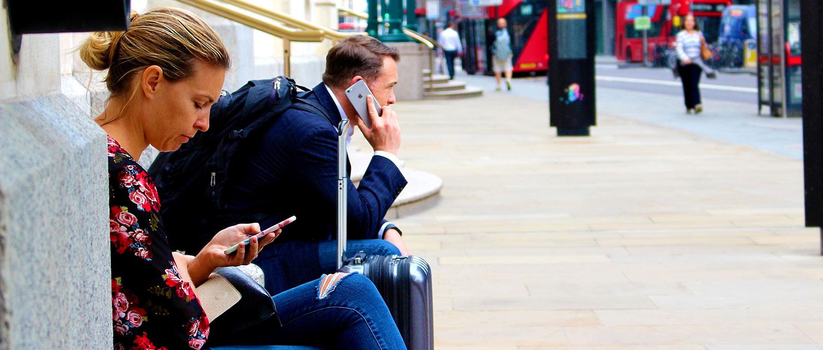 Mann und Frau an ihren iPhones