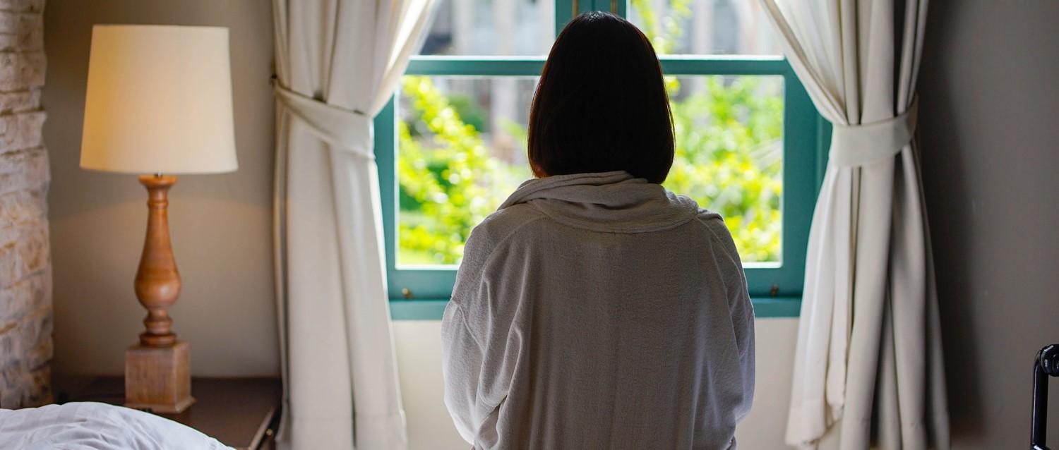 traurige Frau starrt aus dem Fenster