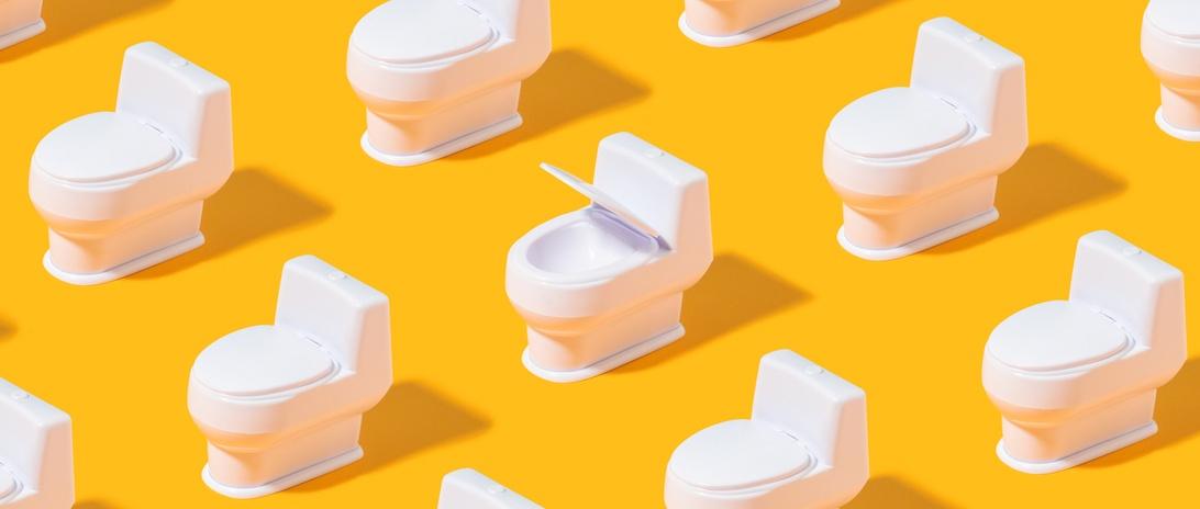 Trendiges Muster mit weißer Toilettenschüssel auf leuchtend orangem Hintergrund.